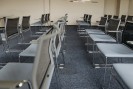 Gezeigt wird eine leere Stuhlreihe in einem Konferenzraum